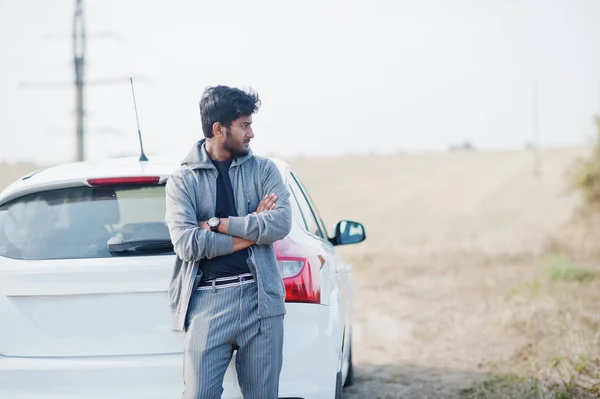 Индийский мужчина в повседневной одежде позировал возле белого автомобиля . — стоковое фото