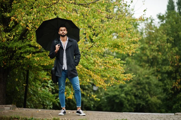 Fashionable tall arab beard man wear on black coat with umbrella