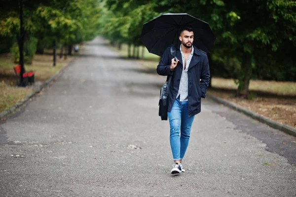 Fashionable tall arab beard man wear on black coat with umbrella