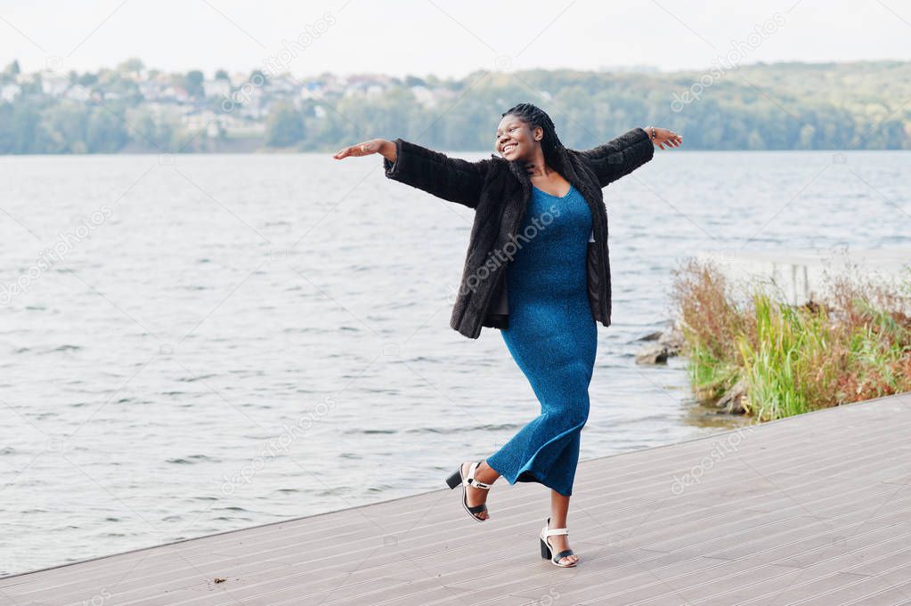 African american dark skinned plus size model posed in a blue sh