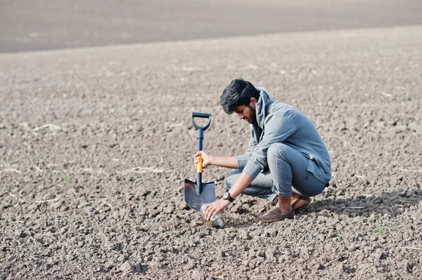 South asian agronomist petani dengan sekop memeriksa tanah hitam . — Stok Foto