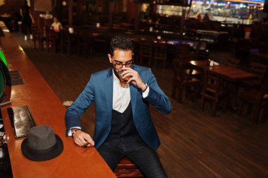 Bir bardak viski ve puro ile yakışıklı, iyi giyimli bir Arap.