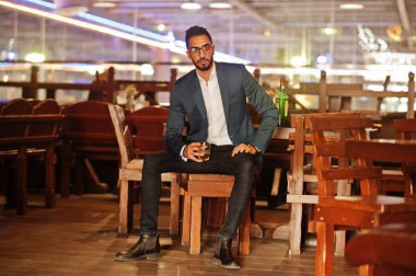 Bir bardak viski ve puro ile yakışıklı, iyi giyimli bir Arap.