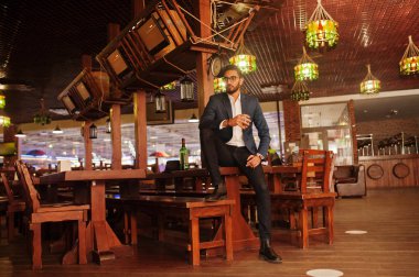 Bir bardak viski ve puro ile yakışıklı, iyi giyimli bir Arap.