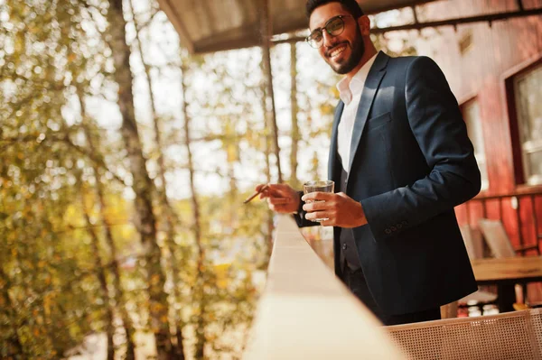 Guapo bien vestido árabe hombre humo cigarro con vidrio de whis — Foto de Stock