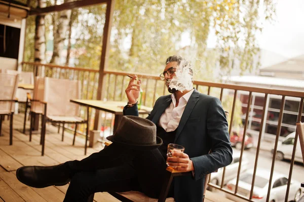 Snygg välklädd arabisk man röker cigarr med glas whis — Stockfoto