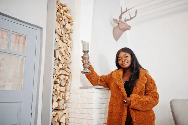 Elegante mujer afroamericana en abrigo naranja posado en la habitación agai — Foto de Stock