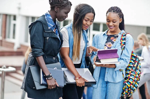 Три африканських студентки жінки позують з рюкзаками і навчають його — стокове фото