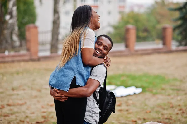 Dos estudiantes africanos con mochila en el patio de la universidad abraza un — Foto de Stock