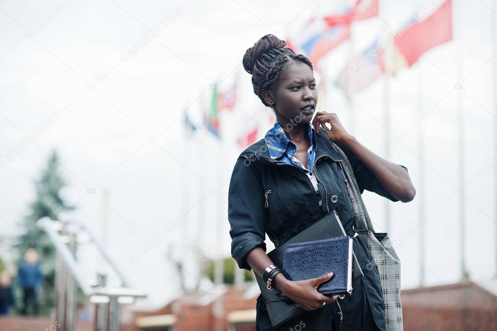 African student female posed with backpack and school items on y