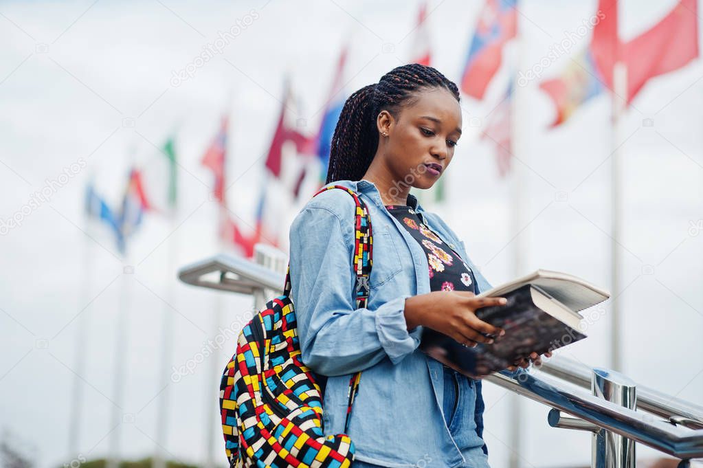 African student female posed with backpack and school items on y
