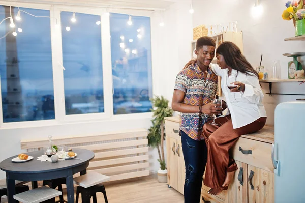 Afro american couple sweethearts drinking wine in kitchen at the — Stock Photo, Image
