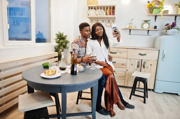 Afro american couple sweethearts drinking wine in kitchen at the