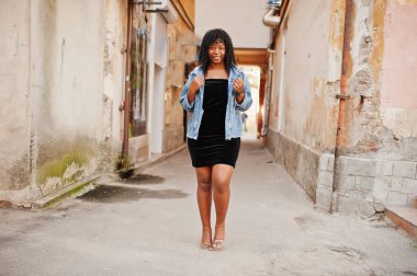 Tarz sahibi afro-Fransız kıvırcık kadın sonbahar günü Je 'de poz verdi