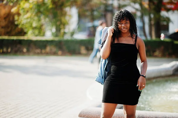 Стильная трэнди-афро-французская кудрявая женщина позировала в осенний день в джинсах — стоковое фото
