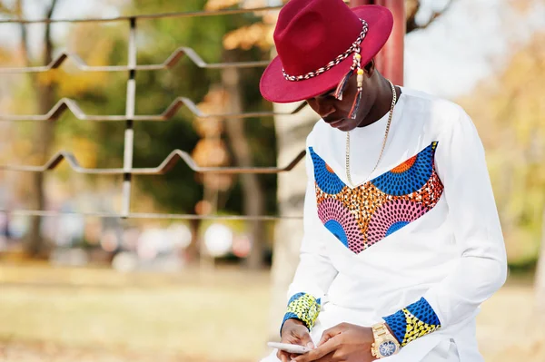 Stijlvolle trendy afro franse man in rode hoed en witte outfit poseerde — Stockfoto
