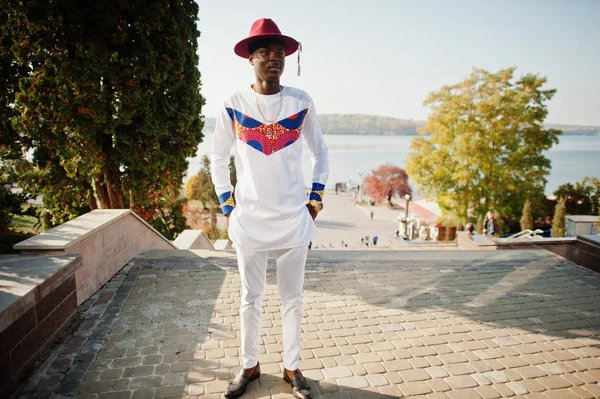 Stijlvolle trendy afro franse man in rode hoed en witte outfit poseerde — Stockfoto