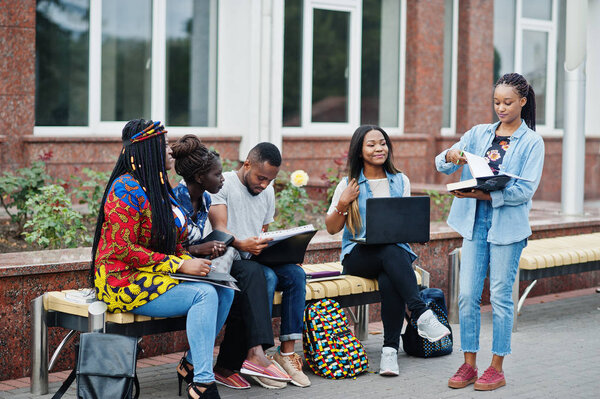 Group of five african college students spending time together on