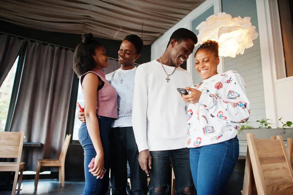 Happy african friends standing and chatting in cafe. Group of bl — Stock Photo, Image