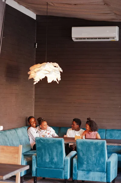 Amigos africanos felizes sentados e conversando no café. Grupo de bla — Fotografia de Stock