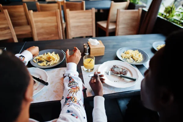 Amigos africanos felizes sentados, conversando no café e comendo comida. Gr — Fotografia de Stock