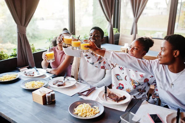 Amigos africanos felizes sentados, conversando no café e comendo comida. Gr — Fotografia de Stock