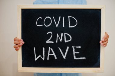 Covid ikinci dalga. Coronavirus konsepti. Çocuk tahtaya yazı yazmış..