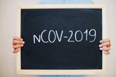 NCOV-2019. Coronavirus konsepti. Çocuk tahtaya yazı yazmış..