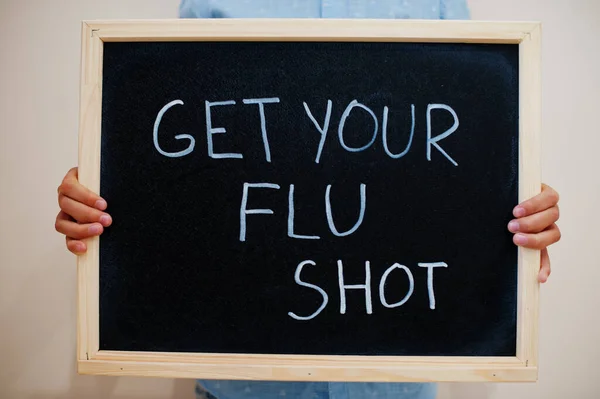 Get your flu shot. Coronavirus concept. Boy hold inscription on the board.