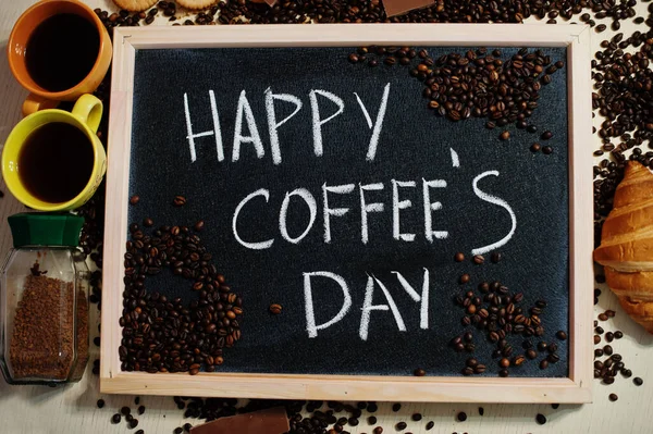 Happy coffee\'s day. Words on blackboard flat lay.