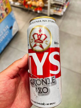 Krakow, Polonya - 08 Temmuz 2025: El ele tutuşan Tyskie içecek kutusu, arka planda bir perakende mağazasının iç yüzünü gösteriyor.