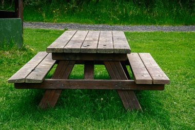 İzlanda 'da canlı yeşil çimlerin üzerinde sağlam bir ahşap piknik masası.