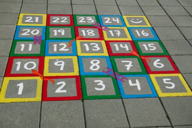 Sayılar, yılanlar ve kaldırıma boyanmış merdivenlerle dolu canlı bir oyun tahtası.