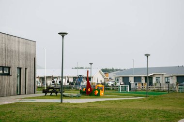 İzlanda 'nın sakin bir kasabasında konut evleri ve yeşilliklerle çevrili açık hava çocuk parkı.