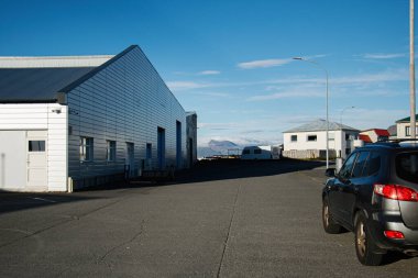 Sanayi binası, konut evleri ve İzlanda manzaralı sessiz bir cadde..