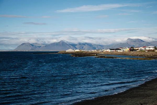 İzlanda 'da dağlar ve okyanus dalgalarıyla çevrili pitoresk bir sahil kasabası..