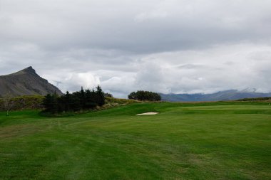 Güzel İzlanda 'da, yemyeşil çimenler ve dağlarla dolu sakin bir golf sahası..