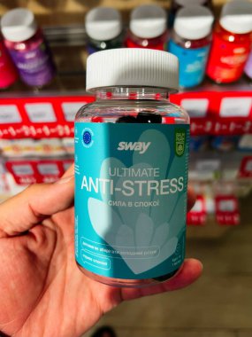 Kyiv, Ukrayna - 10 Ağustos 2025: Bir kişi eczane arka planında tabelalı Anti Stres destek şişesi sergiliyor