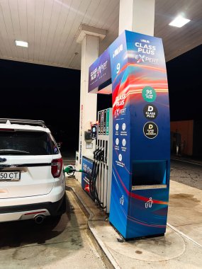 Zagreb, Hırvatistan - 25 Ağustos 2025: Ina benzin pompasındaki beyaz araç floresan ışıkların altında koyu bir arkaplanda