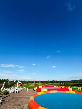 Çevresi yeşilliklerle çevrili canlı bir şişme havuz. Açık havada dinlenmek için cazip bir yol..