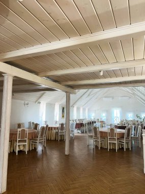 Zarif mobilyaları ve sıcak ahşap zemini olan geniş ışıklı ziyafet salonu.