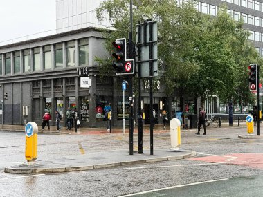 Manchester, İngiltere - 10 Eylül 2025: Manchester, İngiltere 'de yağmurlu bir gün sokak görüntüsü yayalar, trafik ışıkları ve binalar görülüyor.. 
