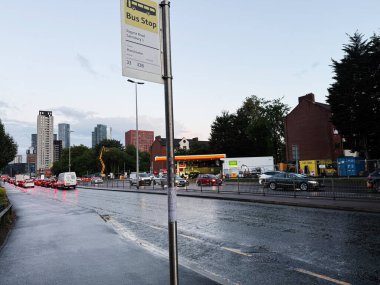Manchester, İngiltere - 10 Eylül 2025: Trafik, tabelalar ve kentsel binaların olduğu Manchester caddesinin akşam manzarası