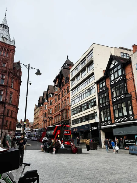 Manchester, İngiltere - 10 Eylül 2025: Tarihi binalar, modern dükkanlar ve yayaların yer aldığı canlı Manchester sokak sahnesi