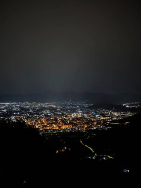 Amalfi, İtalya - 15 Ağustos 2025: Açık gökyüzü altında ışıldayan ışıklarla dolu bir şehir manzarası.