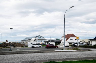 Akranes, İzlanda - 06 Eylül 2025: Akranes, İzlanda 'da evler, park edilmiş araçlar ve bulutlu gökyüzü kentsel ortam