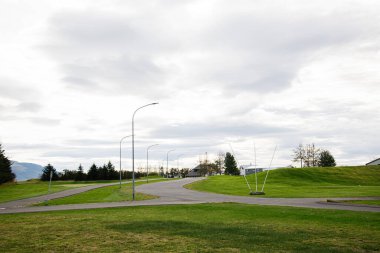 Açık şehir manzarası, temiz yollar, çimenlik alanlar ve İzlanda 'da bulutlu gökyüzü