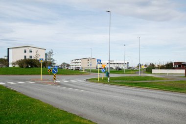 Akranes, İzlanda 'da bulutlu gökyüzünün altında konut ve ticari binalarla çevrili bir kavşak.