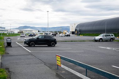 Akranes, İzlanda - 12 Eylül 2025: Akranes, İzlanda 'da bulutlu bir gökyüzü altında arabaların yer aldığı bir otopark.