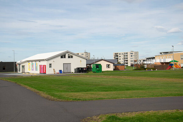 Местные здания в окружении зелени в Акранесе, Исландия под ясным голубым небом